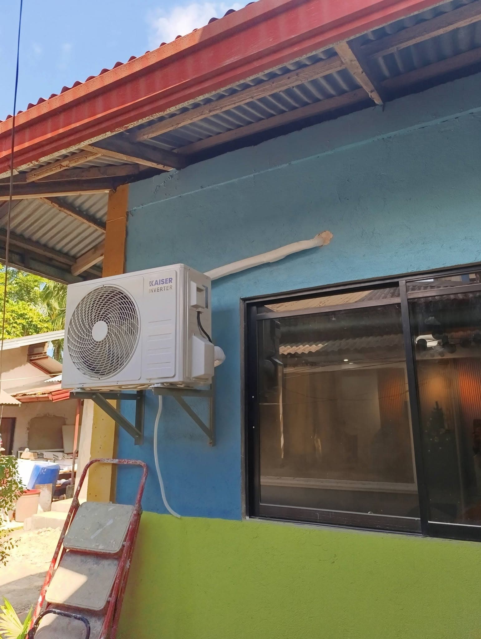 Completed Kaiser inverter condenser mounted on exterior wall brackets with insulated line routing.