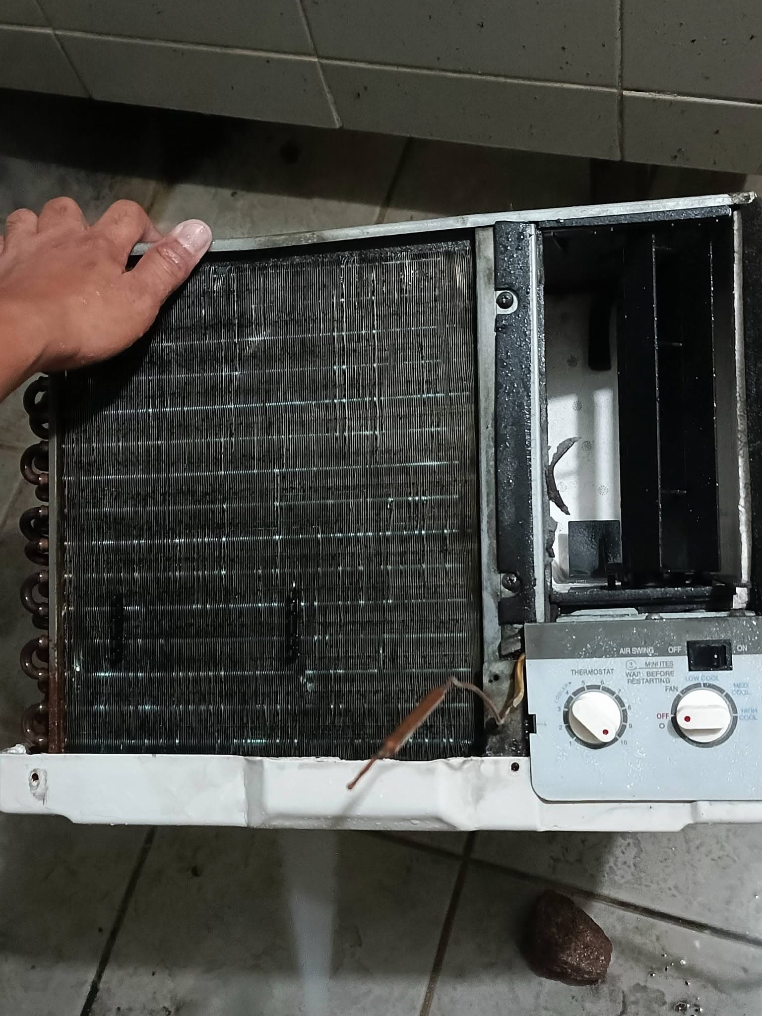 Freshly washed window air conditioner with clean wet coil and internal air outlet.