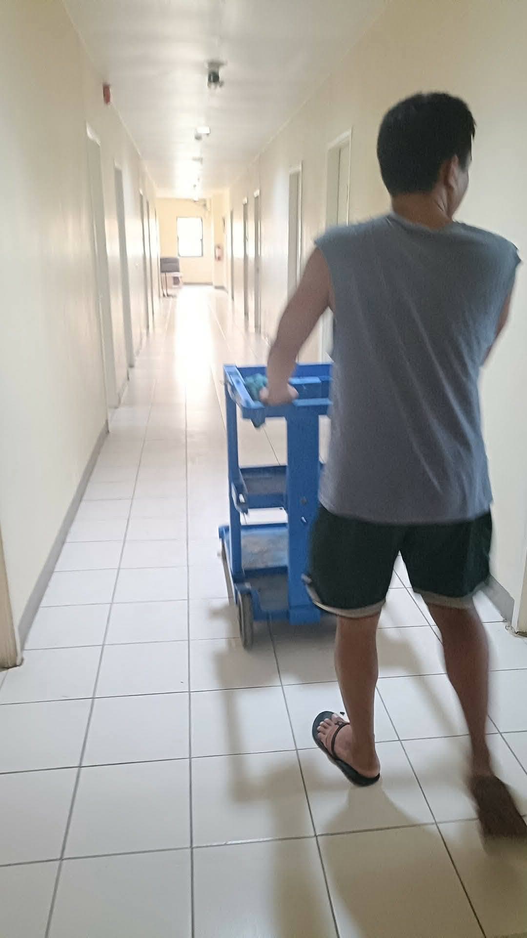 Technician moving service equipment through the building after cleaning the air conditioners.