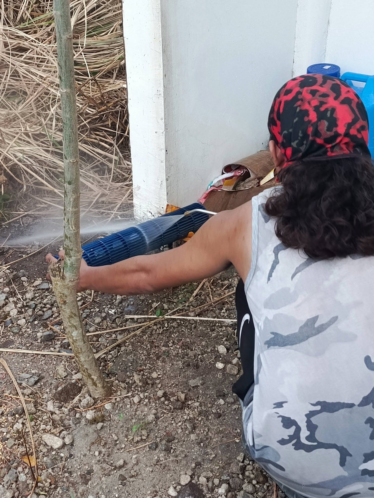 Technician washing the removed blower wheel during the air-conditioning installation.