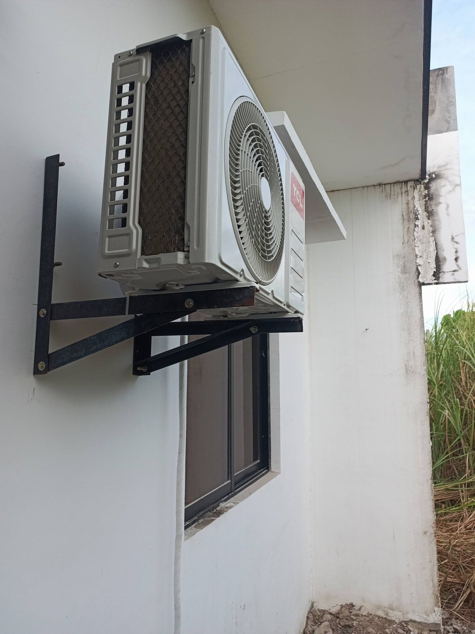 Completed outdoor condenser mounted securely on a steel wall bracket.