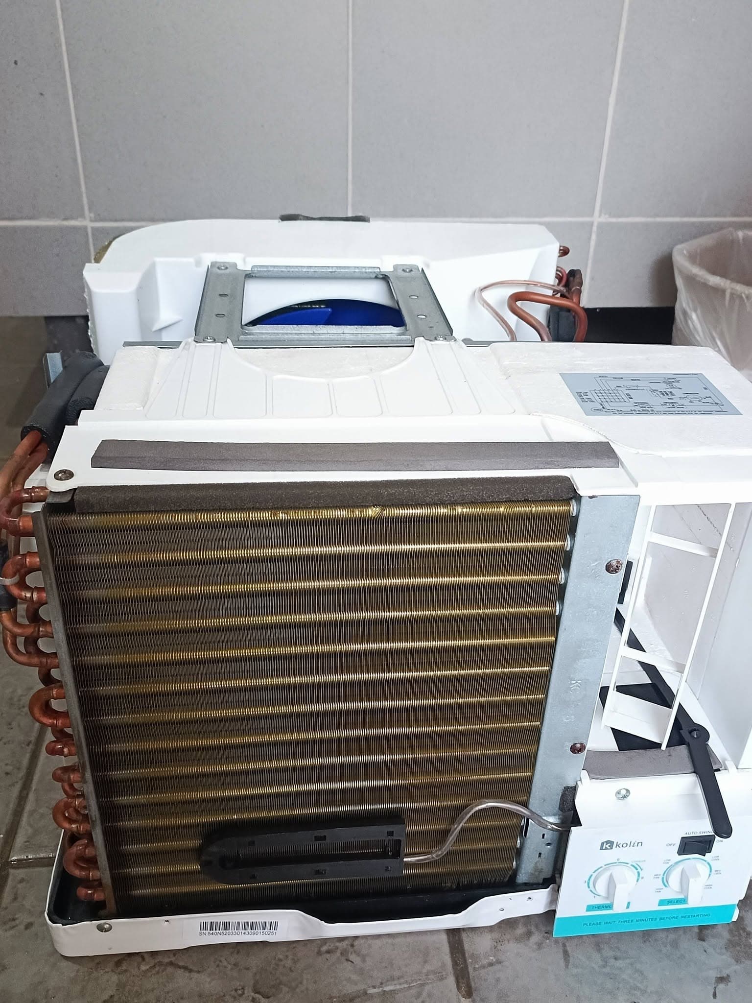 Freshly cleaned window air-conditioning unit with clear coil fins and fan housing.